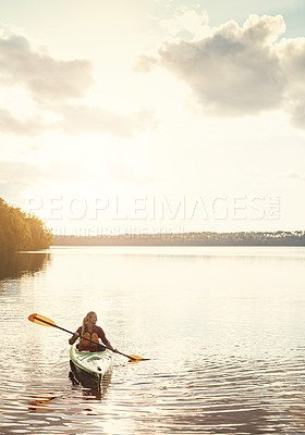 Buy stock photo Shot of an attractive young woman out for canoe ride on the lake