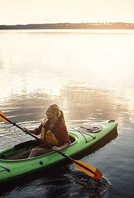 Buy stock photo Shot of an attractive young woman out for canoe ride on the lake