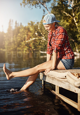 Buy stock photo Shot of a happy young woman spending time by the lakeside