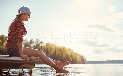 Buy stock photo Shot of a happy young woman spending time by the lakeside