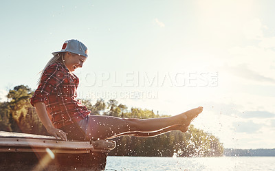 Buy stock photo Shot of a happy young woman spending time by the lakeside