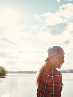 Buy stock photo Shot of a happy young woman spending time by the lakeside