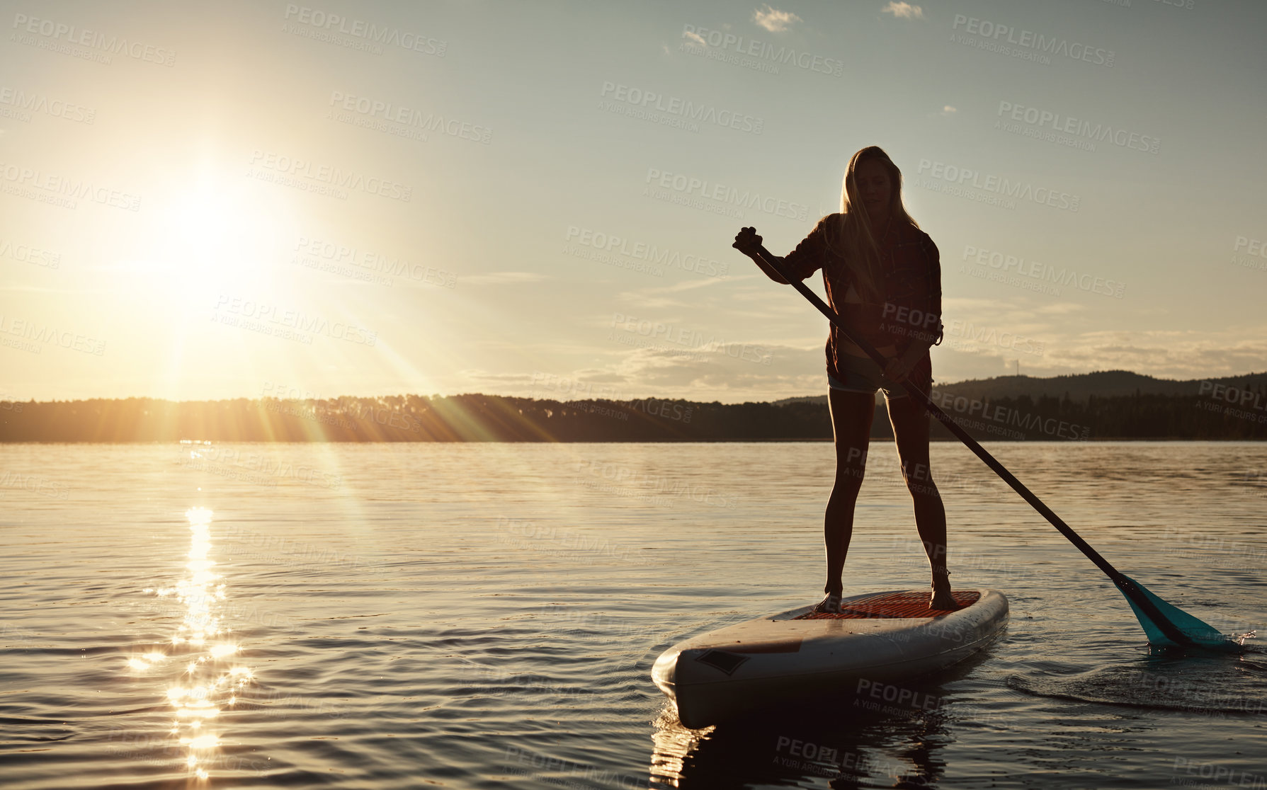 Buy stock photo Lake, sunset and woman on paddle board for relax, water sports and vacation on river for tourism. Sunlight, summer and holiday in Germany for female person with silhouette, swimsuit and travel