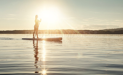 Buy stock photo Lake, sunset and woman on paddle board to relax, water sports and vacation on river for tourism. Sunlight, summer and holiday in Germany for female person, swimsuit and travel fitness for adventure