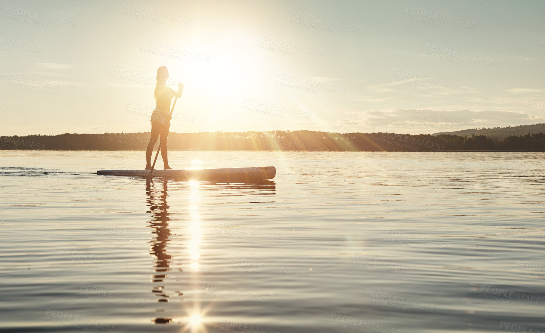 Buy stock photo Lake, sunset and woman on paddle board to relax, water sports and vacation on river for tourism. Sunlight, summer and holiday in Germany for female person, swimsuit and travel fitness for adventure