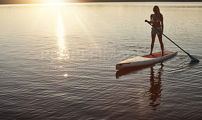 Buy stock photo Lake, sunset and woman on paddle board for relax, water sports and vacation on river for tourism. Sunlight, summer and holiday in Germany for female person, swimsuit and travel fitness for adventure