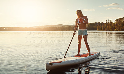 Buy stock photo Lake, sunset and woman on paddle board to relax, water sports and vacation on river for tourism. Sunshine, summer and holiday in Germany for female person, swimsuit and travel fitness for adventure