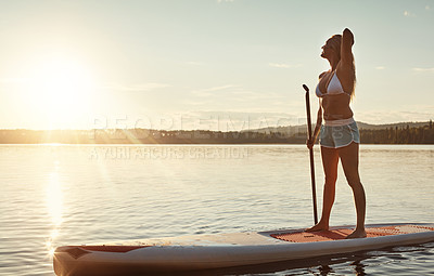 Buy stock photo Lake, sunset and woman on paddle board for exercise, water sport and vacation on river for tourism. Sunshine, summer or holiday in Germany for female person, swimsuit or travel fitness for adventure