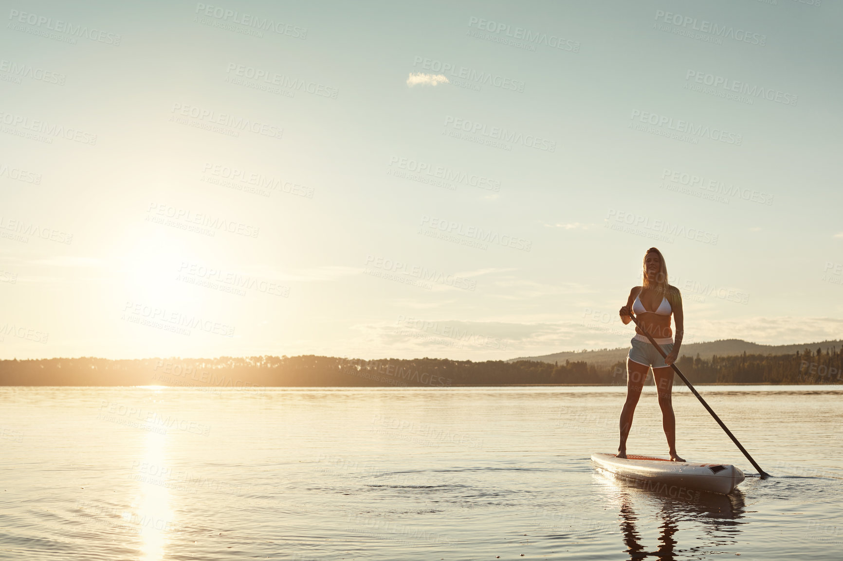 Buy stock photo River, sunset and woman on paddle board with sunshine, water sport and vacation on lake for tourism. Exercise, summer or holiday in Germany for female person, swimsuit or travel fitness for adventure