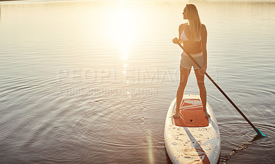 Buy stock photo Lake, sunset and woman on paddle board with sunshine, water sport and vacation on river for tourism. Fitness, summer or holiday in Germany for female person, swimsuit or travel exercise for adventure