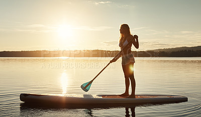 Buy stock photo Lake, sunset and woman on paddle board for balance, water sport and vacation on river for tourism. Nature, summer or holiday in Germany for female person, swimsuit or travel exercise for adventure