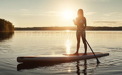 Buy stock photo Lake, sunset and woman on paddle board for balance, water sport and vacation on river for tourism. Nature, summer or holiday in Germany for female person, swimsuit or travel exercise for adventure