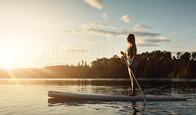 Buy stock photo Lake, sunset and woman on paddle board with trees, water sport and vacation on river for tourism. Exercise, woods or holiday in Germany for female person, swimsuit or travel fitness for adventure