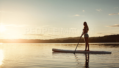 Buy stock photo Lake, sunshine and woman on paddle board for water sport, forest and vacation on river for tourism. Exercise, woods or holiday in Germany for female person, swimsuit or travel fitness for adventure