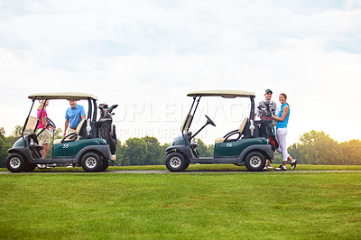 Buy stock photo Shot of two couples with golf carts spending a day on the golf course