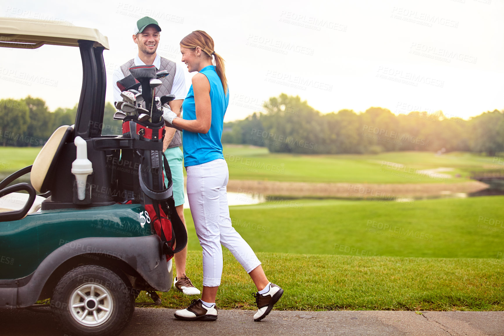 Buy stock photo Shot of an affectionate young couple spending a day on the golf course