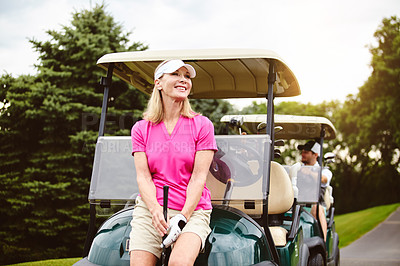 Buy stock photo Cropped shot of an attractive mature woman leaning against a golf cart on a golf course