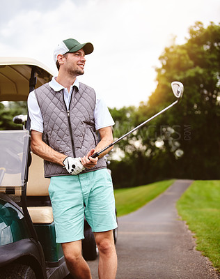 Buy stock photo Cropped shot of a handsome young man leaning against a golf cart on a golf course