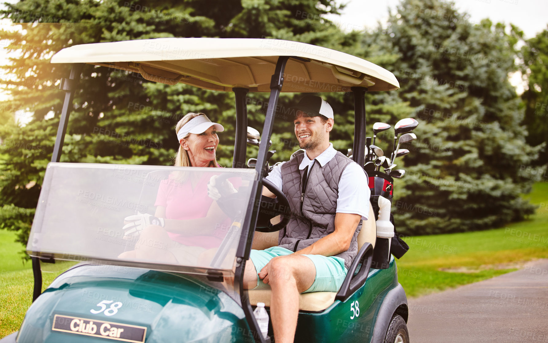 Buy stock photo Cropped shot of a handsome young man and his mother driving a golf cart on a golf course