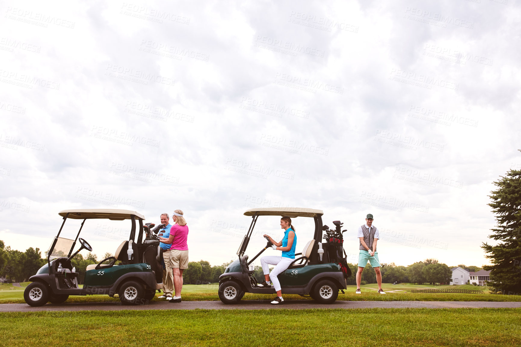 Buy stock photo Shot of two couples with golf carts spending a day on the golf course