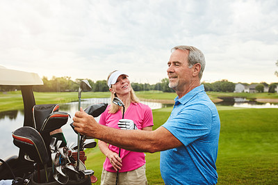 Buy stock photo Shot of an affectionate mature couple spending a day on the golf course