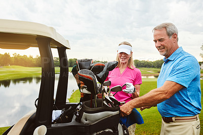 Buy stock photo Shot of an affectionate mature couple spending a day on the golf course