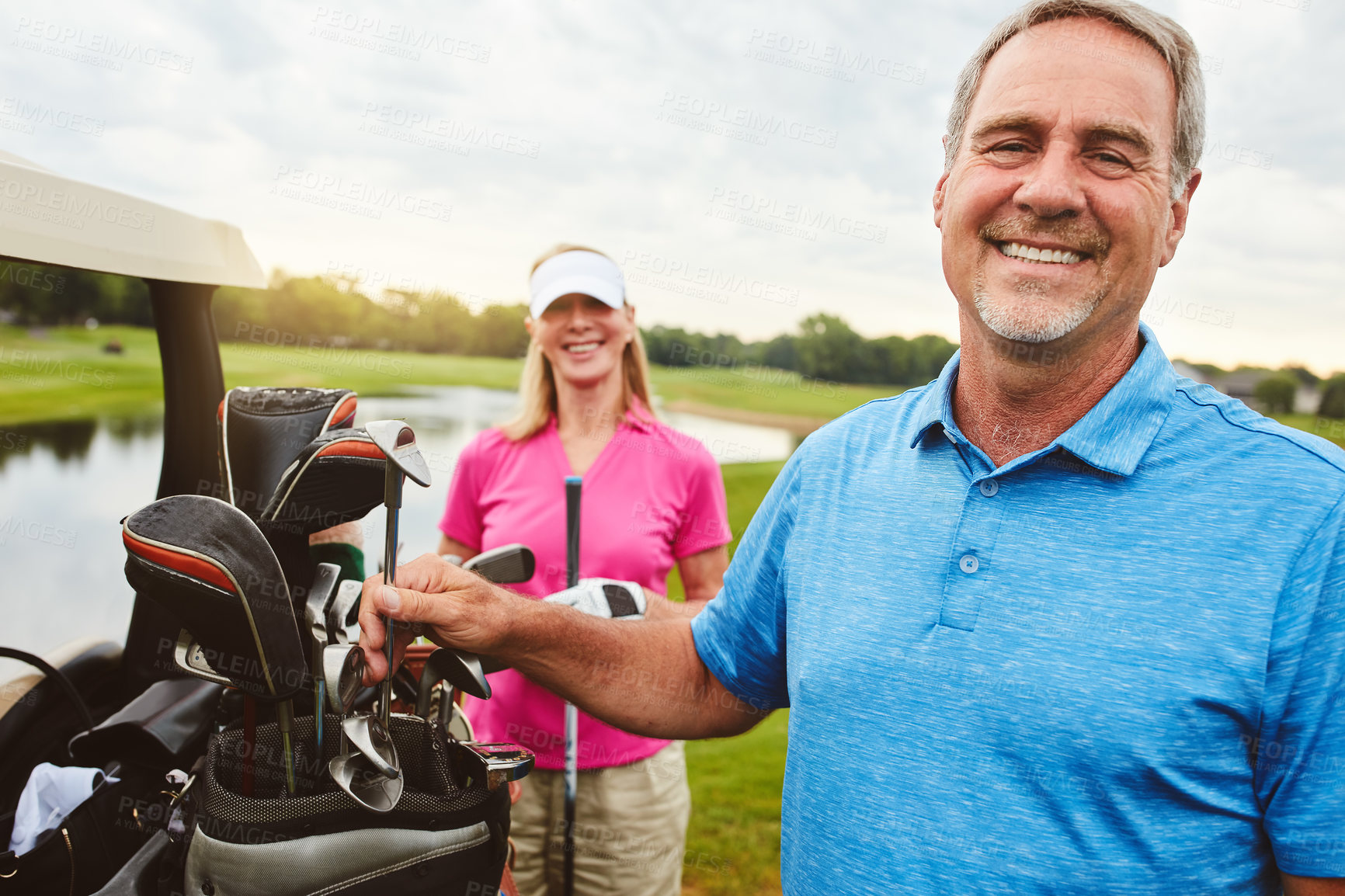 Buy stock photo Shot of an affectionate mature couple spending a day on the golf course