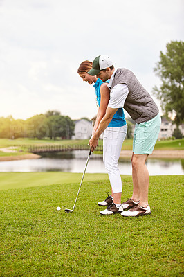 Buy stock photo Shot of an affectionate young couple spending a day on the golf course