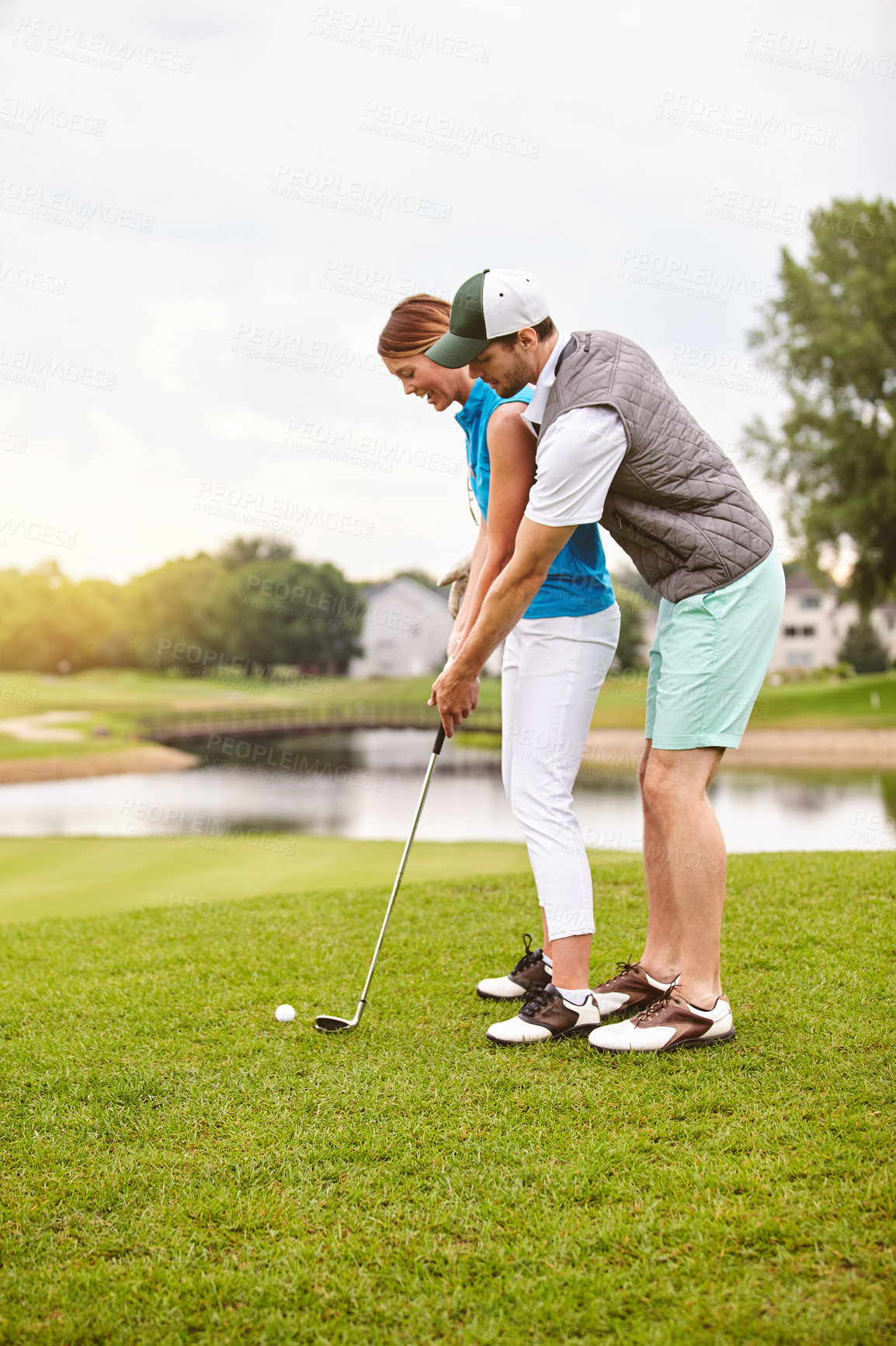 Buy stock photo Shot of an affectionate young couple spending a day on the golf course