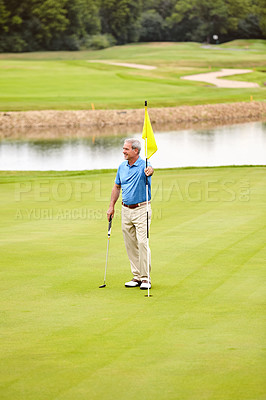 Buy stock photo Shot of a mature man out playing golf in his free time