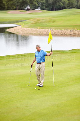 Buy stock photo Shot of a mature man out playing golf in his free time