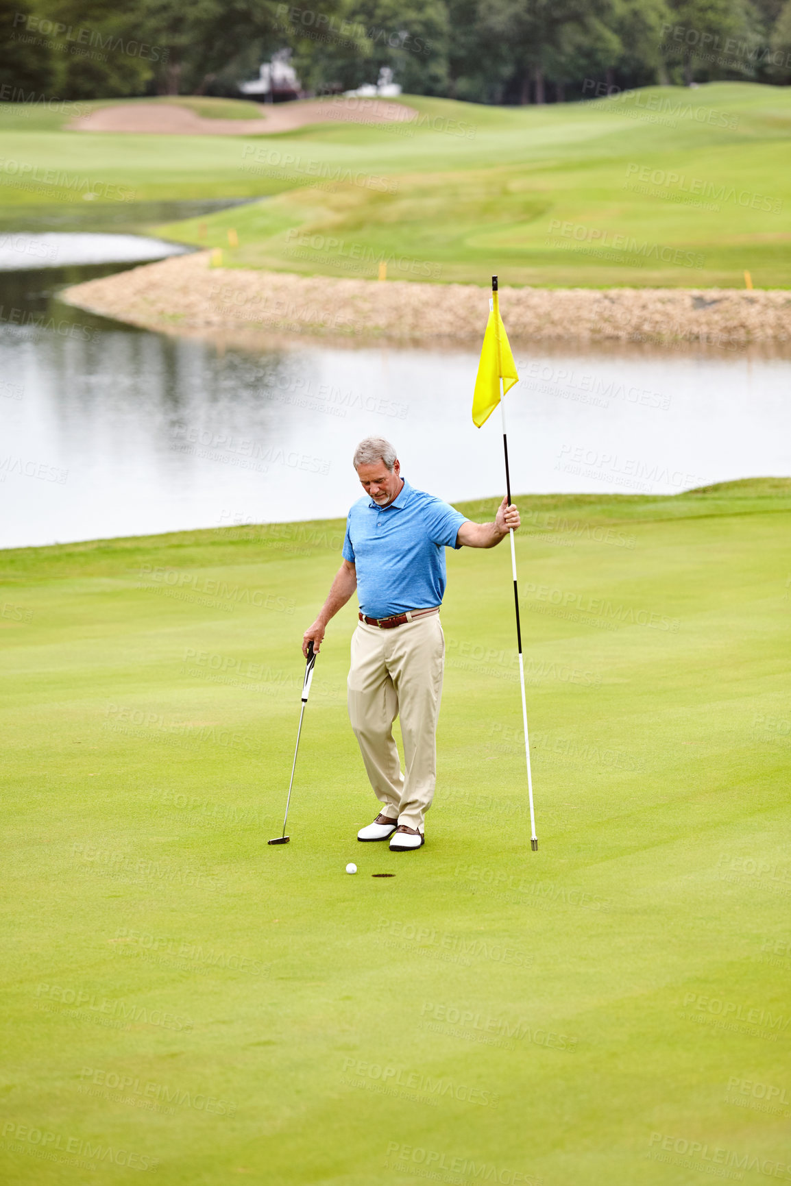 Buy stock photo Shot of a mature man out playing golf in his free time