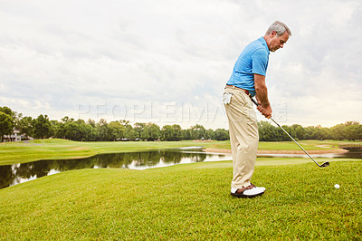 Buy stock photo Shot of a mature man out playing golf in his free time