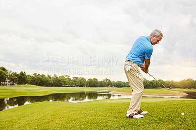 Buy stock photo Shot of a mature man out playing golf in his free time