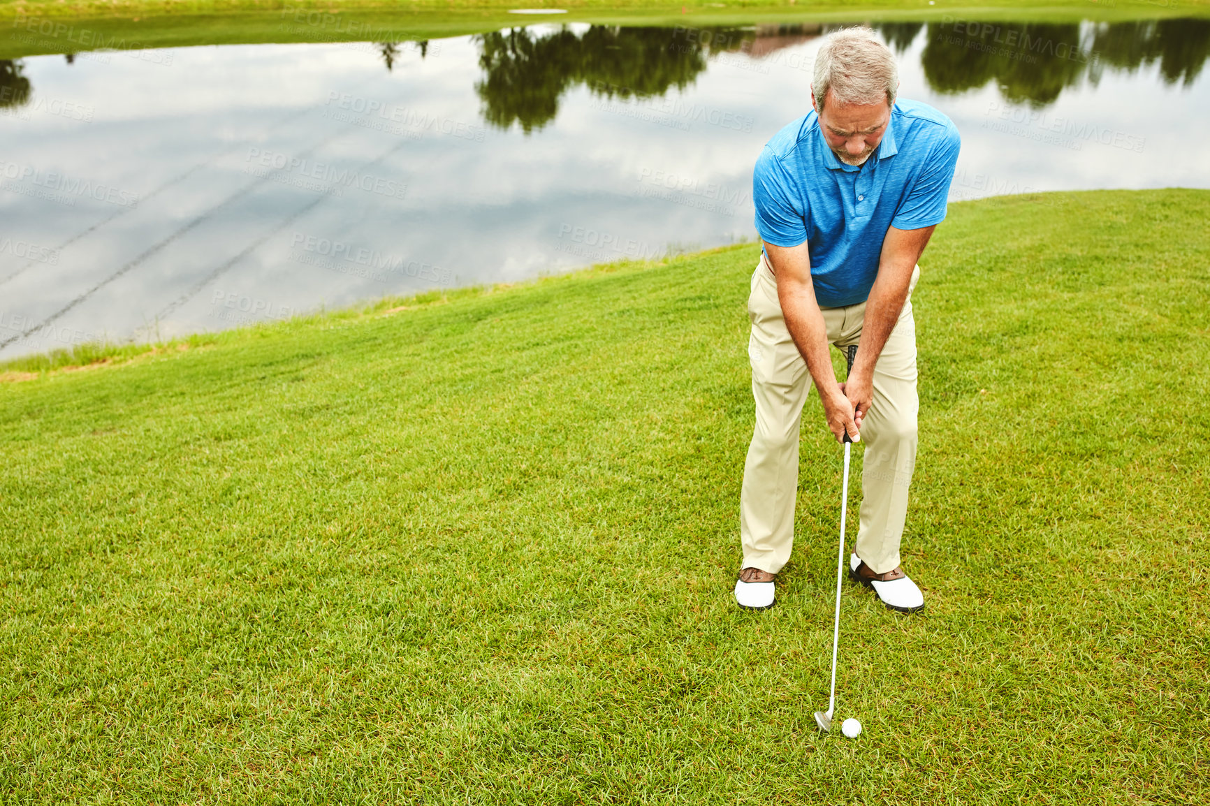 Buy stock photo Mature, man and stroke on field by golf course with club for target practice, skill and precision or training for tournament. Male golfer, lake and thoughts for game plan, shot strategy and exercise