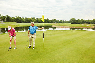 Buy stock photo Shot of a mature couple out playing golf together