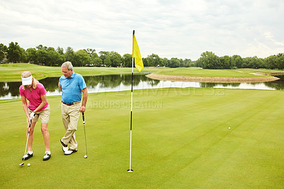 Buy stock photo Shot of a mature couple out playing golf together