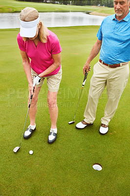 Buy stock photo Sports, couple and golf hole with golfing club on course for game training, target and competition match. Mature, man and woman shooting with equipment on field, hit ball and turf stroke for contest