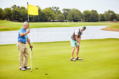 Buy stock photo Shot of two friends out playing golf together in their free time