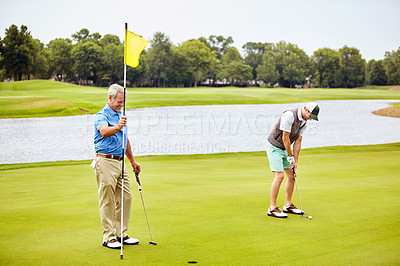 Buy stock photo Shot of two friends out playing golf together in their free time