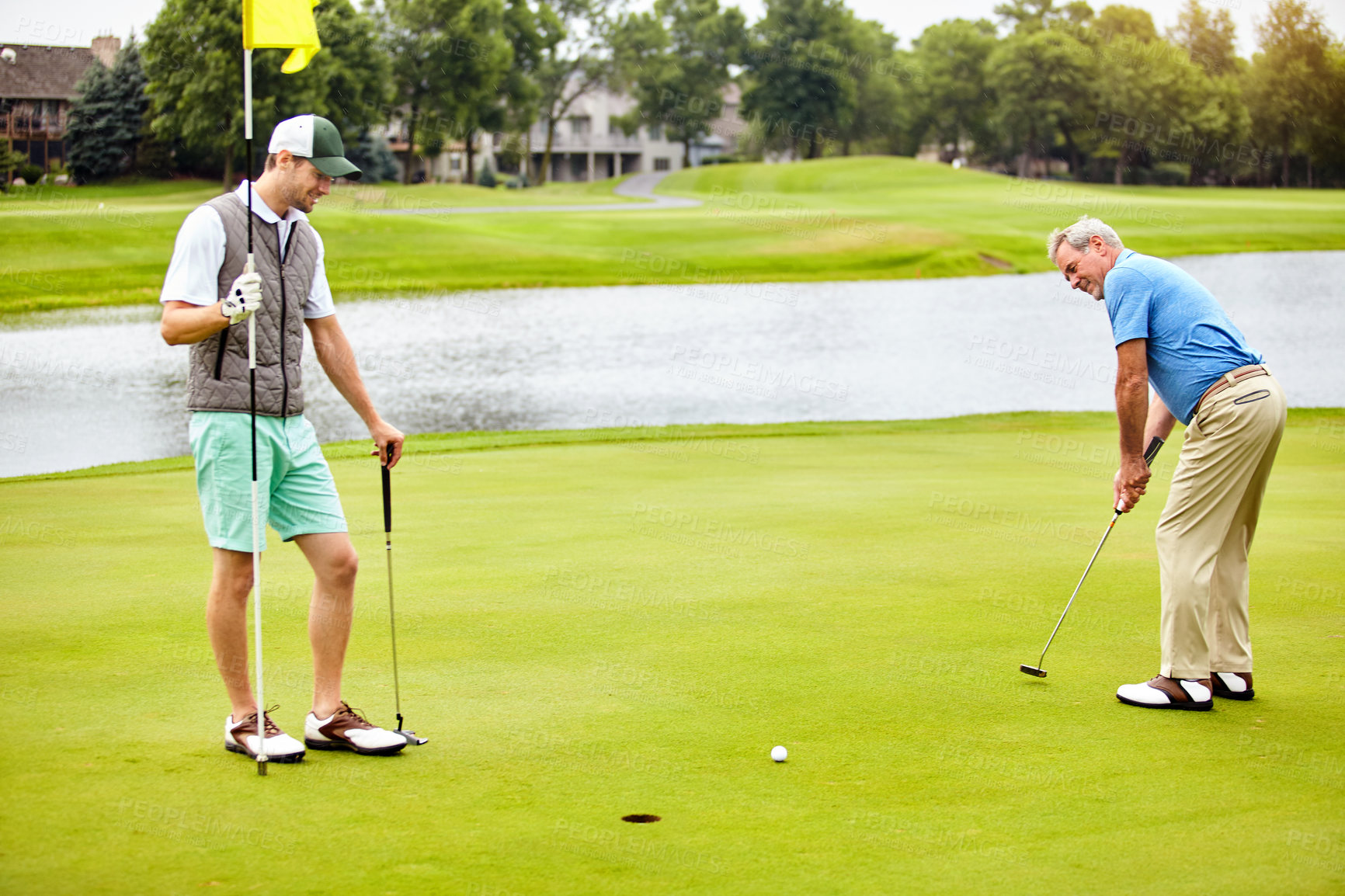 Buy stock photo Men, golf and playing on green for tee off in training as members of club for health, wellness or business. Male people, putter and hole for sports, exercise or meeting as partner in company for deal