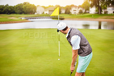 Buy stock photo Shot of a young man out playing golf on the golf course