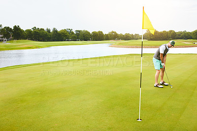 Buy stock photo Shot of a young man out playing golf on the golf course