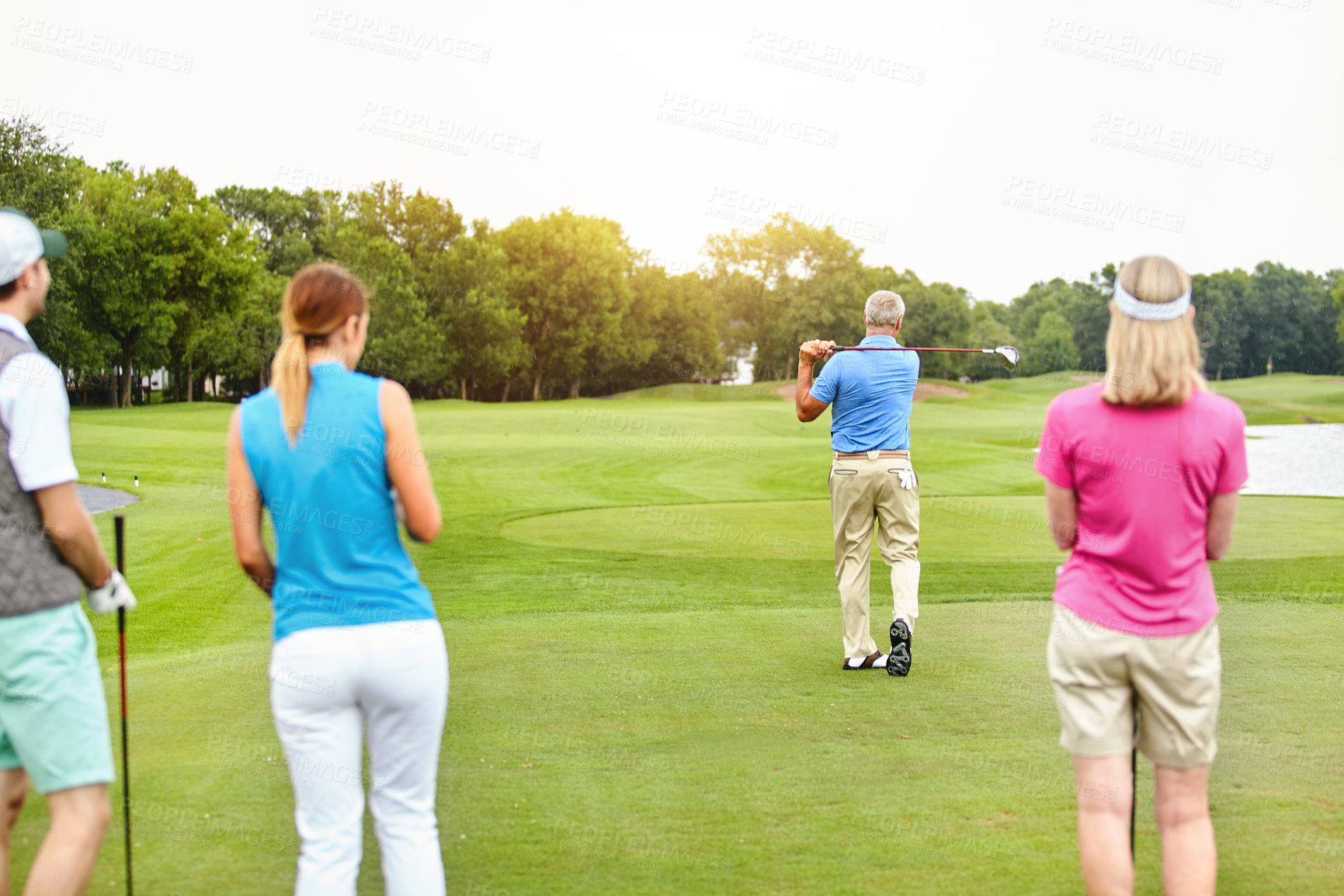 Buy stock photo Team, golf and back in outdoor for tee, swing in group as members in club for health, wellness or bonding. People, putter and hole for sports, exercise or meeting as family in country estate for game