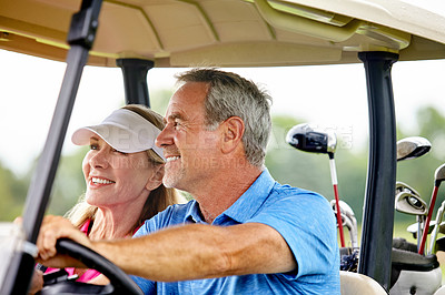 Buy stock photo Shot of a couple riding in a golf cart on a golf course