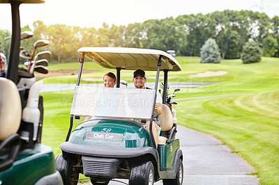 Buy stock photo Shot of a couple riding in a golf cart on a golf course