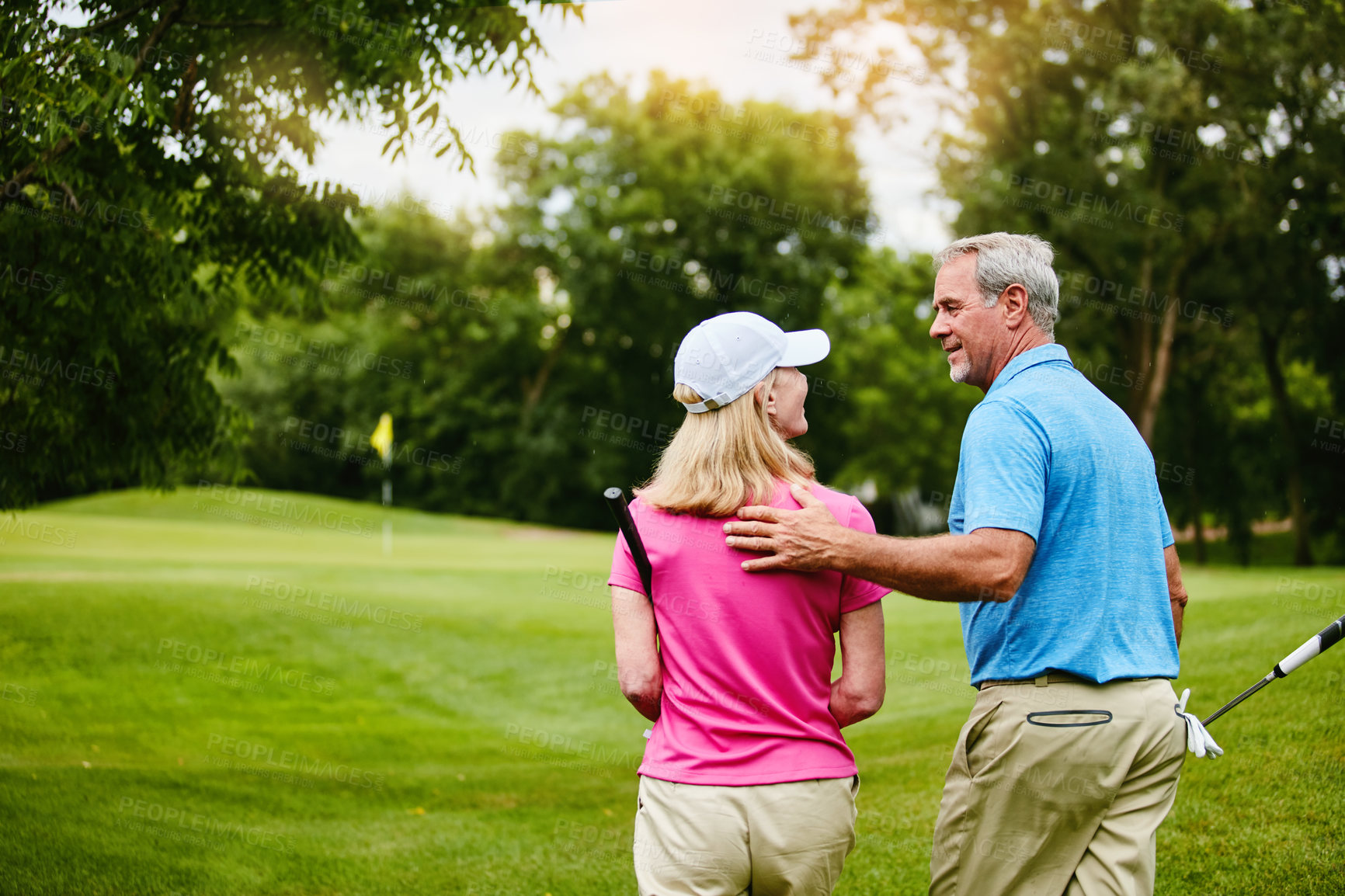 Buy stock photo Mature, couple and walking back on golf course, outside and healthy fitness activity with golfers together at club. Relaxing, weekend break and care on sport field, nature exercise and people