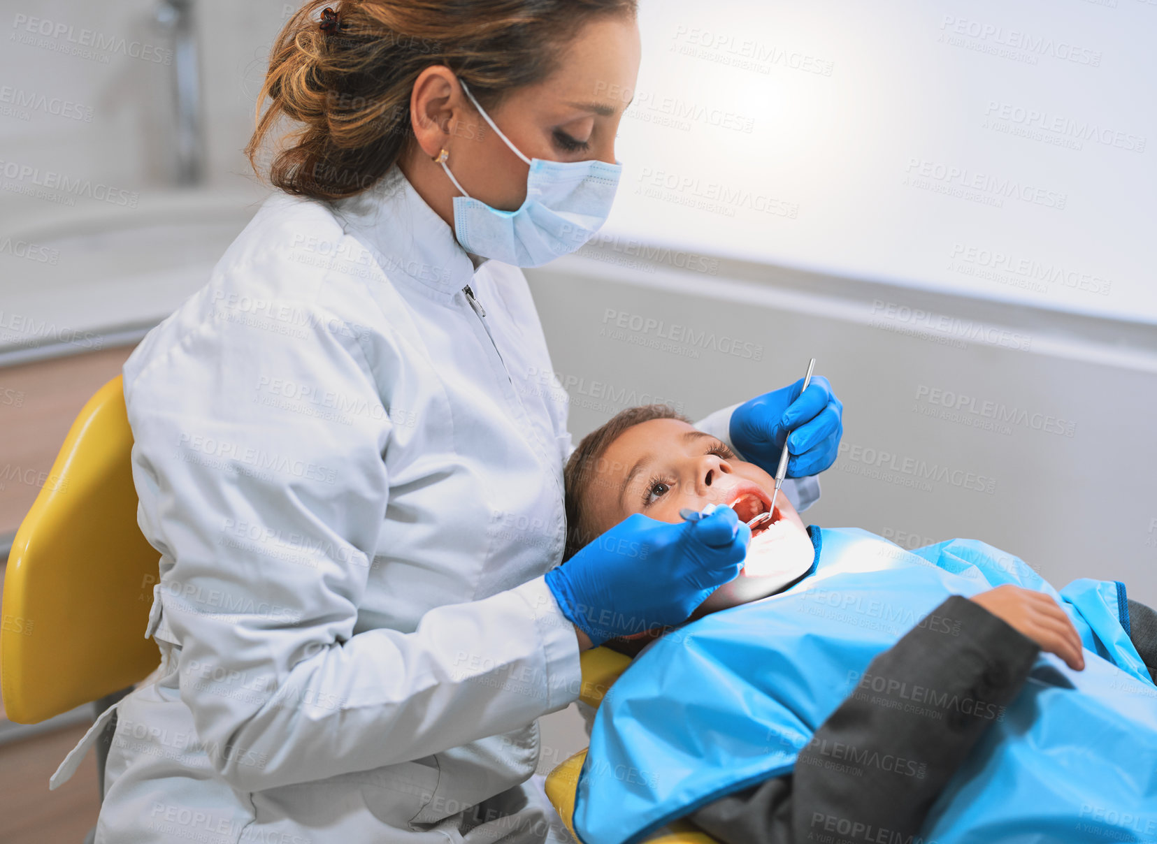 Buy stock photo Woman, dentist and examination with child in hospital for procedure preparation in oral care clinic. Female person, patient and protective mask as hygienist for teeth cleaning or root canal treatment