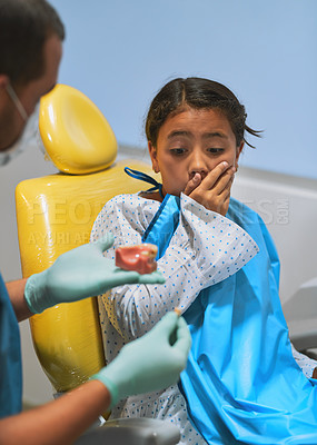 Buy stock photo Child, dentist or scared in clinic for education, learning or gum disease awareness with prop. Specialist, girl or shocked in office for consultation, shared knowledge or information on dental damage