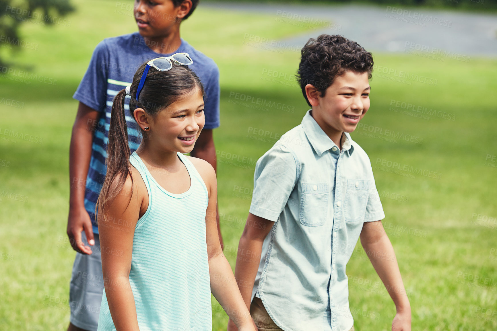 Buy stock photo Shot of a young boy and girl hanging out with friends in the park
